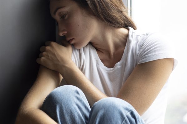 portrait-young-woman-with-low-self-esteem-sitting-by-window-home